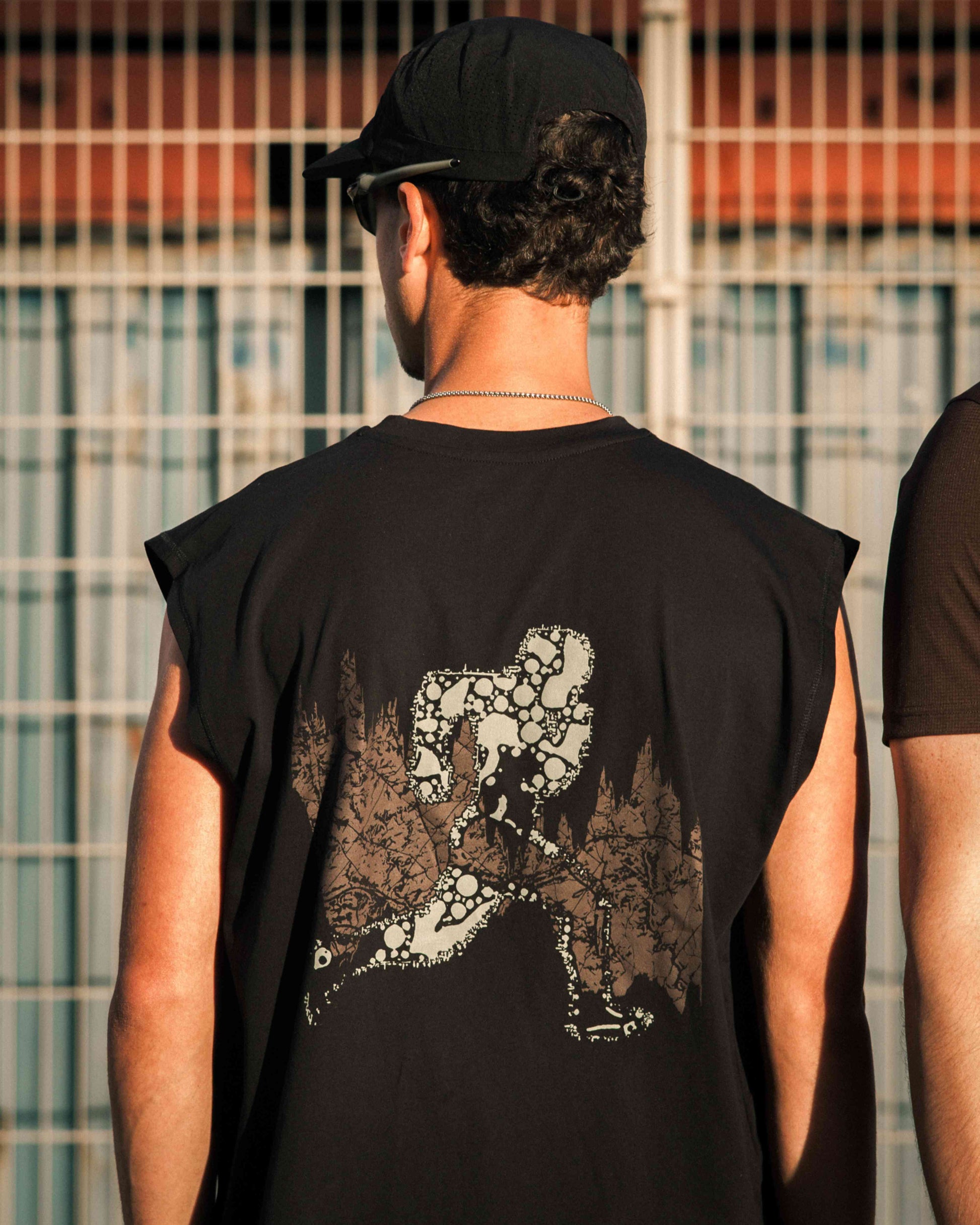 Model in training tank top, Black colour, front view, relaxed fit, wide arm openings